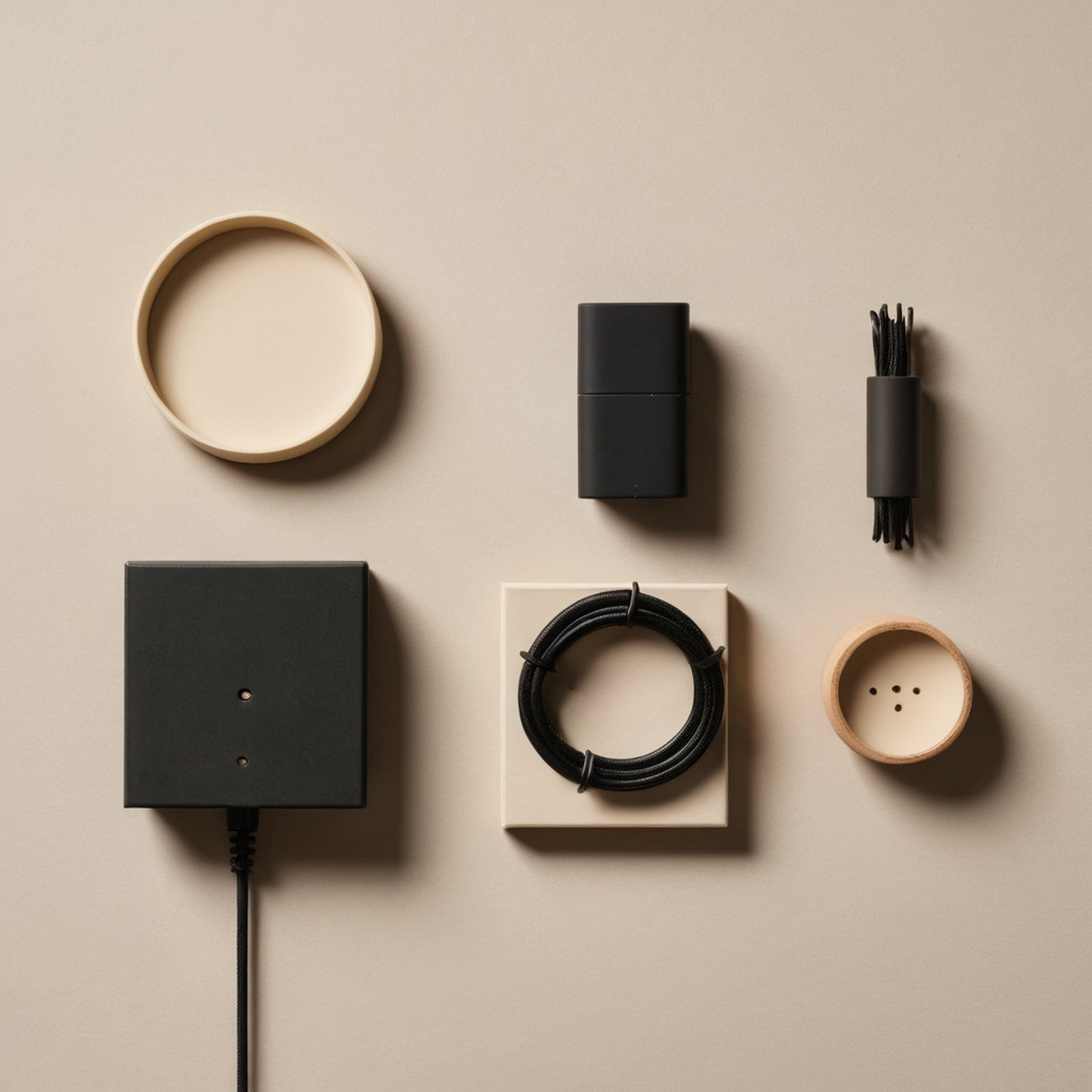 Flat lay of everyday gadgets and cable organisers on a beige background